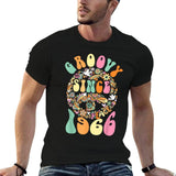 Man wearing a black t-shirt with colorful 'GROOVY SINCE 1966' design.
