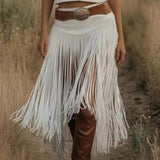 Person wearing a white fringe skirt with brown boots and belt in a natural setting