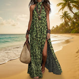 Woman in a green leopard print dress on a beach with palm trees.