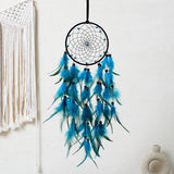 Blue feather dreamcatcher hanging against a white wall with macrame wall art.