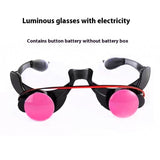 Black rimless-style glasses with bright pink lenses and a red elastic band, shown on a white background with text reading 'Luminous glasses with electricity' and 'Contains button battery without battery box.'.