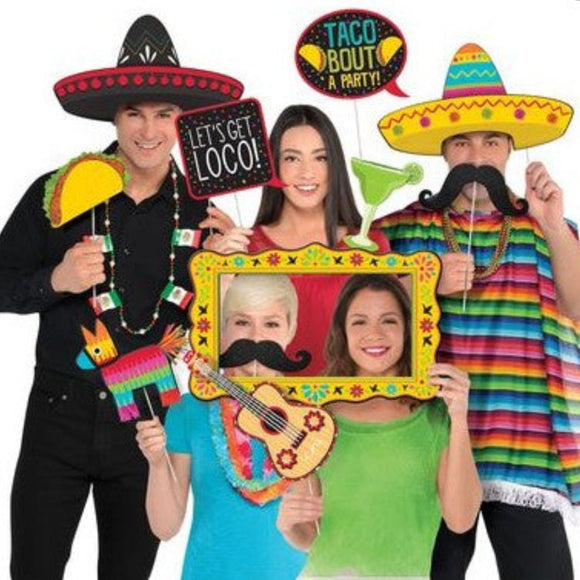 People with Mexican-themed props including sombreros, a piñata, and a guitar frame.