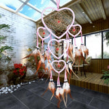 Heart-shaped dreamcatcher with feathers hanging indoors.