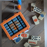 Orange carrying case with New York Knicks logo, surrounded by dominoes.