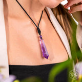 Person wearing a purple crystal  Amethyst necklace 